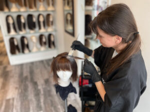 Colourist putting colour in human hair wig